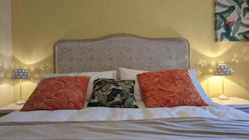 a bed with two pillows on it with two lamps at Chambres d'Hotes CASCAROT in Lechâtelet