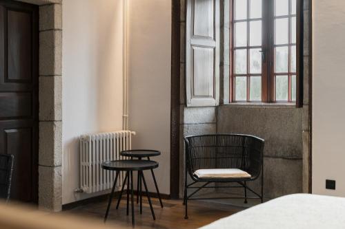a room with two chairs and a table and a window at Pazo da Buzaca in Moraña