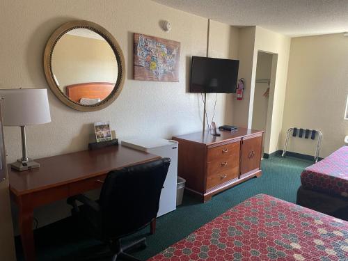 a hotel room with a desk and a mirror at Econo Lodge in Kalamazoo