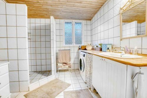 y baño con lavabo y lavadora. en Blmunkevangen 21, 3120 Dronningmlle, en Dronningmølle