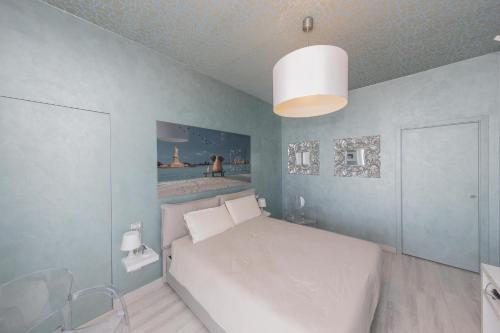 1 dormitorio con cama blanca y pared azul en La Terrazza sul Lago en Verbania