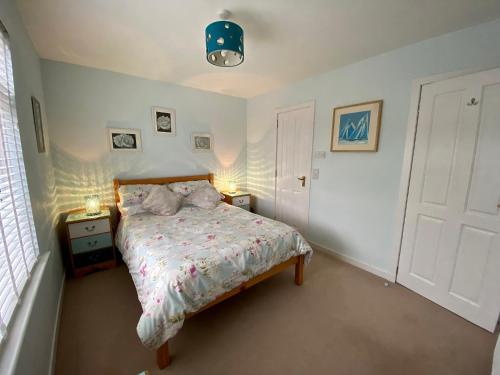 a bedroom with a bed and two lamps and a door at Little Haven in Gairloch