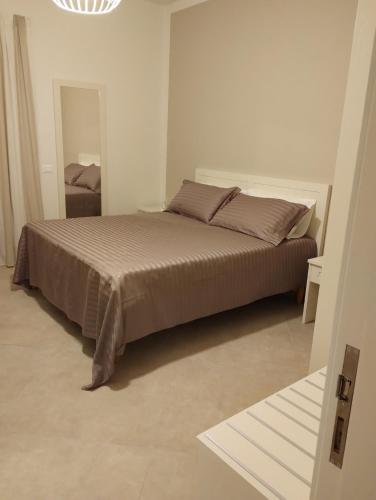 a bedroom with a bed in a white room at LA LAMPARA in Carrara