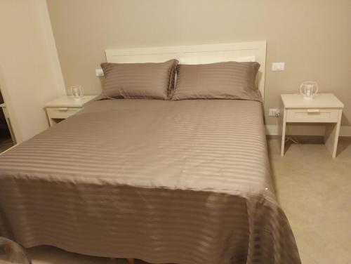 1 cama en un dormitorio con 2 mesitas de noche en LA LAMPARA, en Carrara