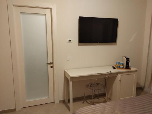 Habitación con escritorio y TV en la pared. en LA LAMPARA, en Carrara