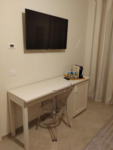 a white desk with a television on a wall at LA LAMPARA in Carrara