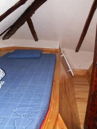 a bedroom with a blue bed in a attic at Galetas 50 in Saint-Étienne-de-Tinée