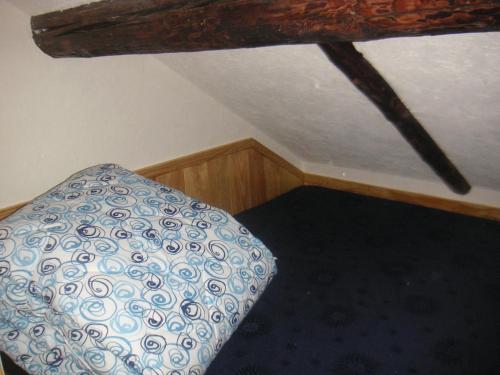 a attic room with a bed and a ceiling at Galetas 50 in Saint-Étienne-de-Tinée
