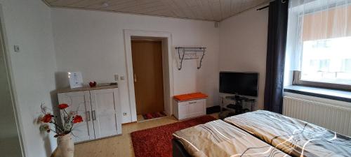 une chambre avec un lit et une télévision dans l'établissement Zur alten Schmiede - Breitenbrunn/Erzgebirge, à Breitenbrunn/Erzgeb.