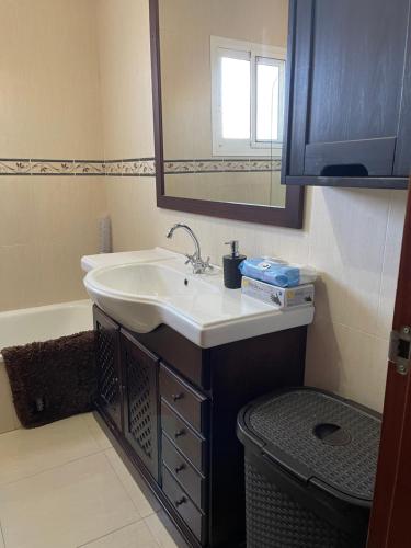 een badkamer met een wastafel, een spiegel en een bad bij Casa Bornes in Sanlúcar de Barrameda