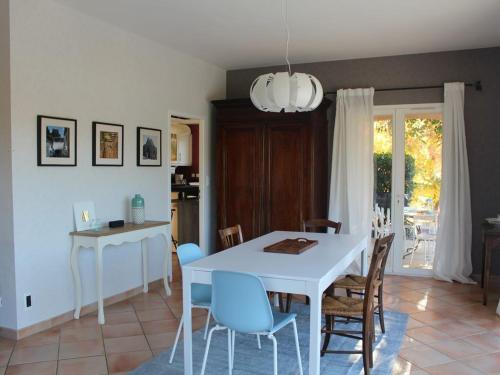 a dining room with a white table and chairs at Villa les Rosiers in Tallard
