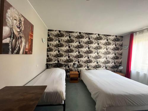 - une chambre avec 2 lits et un tableau mural dans l'établissement Hôtel Les Jardins Dunkerque centre, à Dunkerque