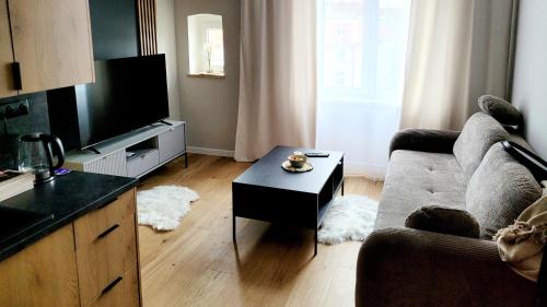 ein Wohnzimmer mit einem Sofa und einem Couchtisch in der Unterkunft Justinrent 1 in Legnica