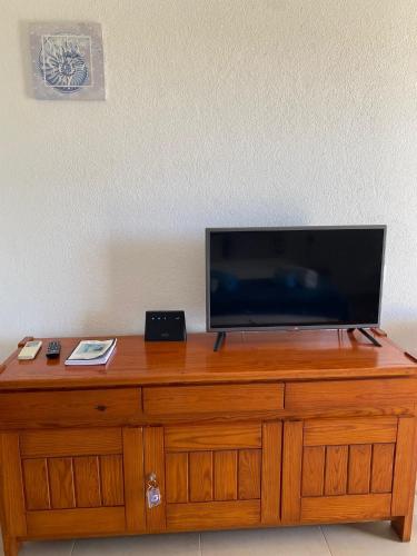 a flat screen tv sitting on top of a wooden dresser at Perfect Summer in Cabanas de Tavira