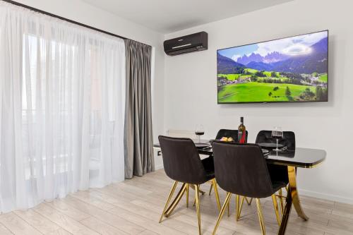 a dining room with a black table and chairs at The Central Deluxe in Bucharest