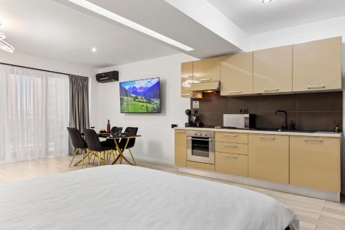 a bedroom with a bed and a kitchen with a table at The Central Deluxe in Bucharest
