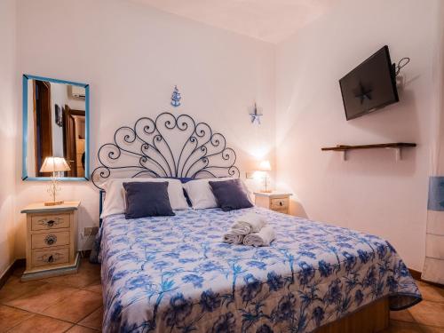 um quarto com uma cama com um edredão azul e branco em Sardinia Family Villas - Cannigione Beach Apartments em Cannigione