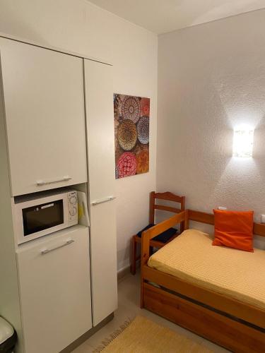 a small room with a bed and a refrigerator at Perfect Summer in Cabanas de Tavira