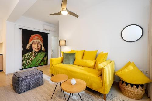 a yellow couch in a living room with a painting at Aretousa InCreteble Cretan Residences Collection in Sitia