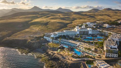 eine Luftansicht eines Resorts in der Nähe des Wassers in der Unterkunft Secrets Lanzarote Resort & Spa - Adults Only (+18) in Puerto Calero