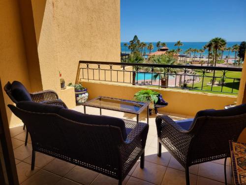 a balcony with chairs and a table and a view of the ocean at 301 C Princesa de peñasco in Puerto Peñasco