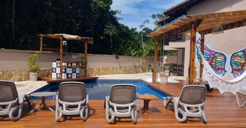 un patio avec des chaises et une piscine dans l'établissement WINNER BEACH HOTEL, à Juréia
