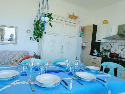 サン・レオーネにあるcasa Rituzzaの青いテーブルクロスに皿と眼鏡をかけた青いテーブル