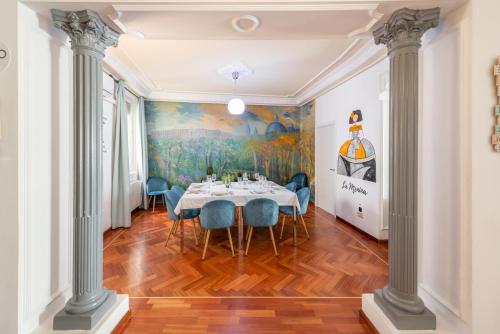 a dining room with a table and blue chairs at vip LETRAS, by MONARO in Madrid