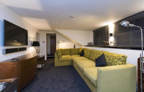 a living room with a couch and a tv at The Mayfield Seamer in Scarborough