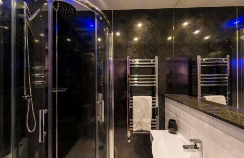 a bathroom with a glass shower and a sink at The Mayfield Seamer in Scarborough
