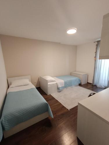 Cette petite chambre comprend 2 lits et une fenêtre. dans l'établissement Apartman A&D, à Ljubuški