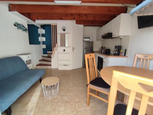 une cuisine et un salon avec une table et un canapé dans l'établissement AZUR ET SOLEIL Jolie Maisonnette climatisée proche de la mer Richelieu Cap d'Agde, au Cap d'Agde