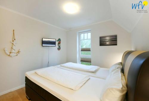 a bedroom with two beds and a window at Bootshaus in den Duenen - 5 - "Ferienwohnung Strandgut" in Wangerooge