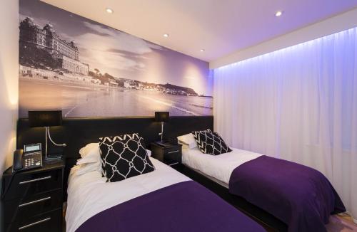 duas camas num quarto com um quadro na parede em The Mayfield Seamer em Scarborough