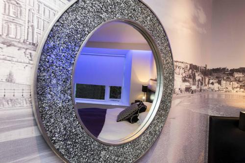 a mirror on a wall with a bed in a room at The Mayfield Seamer in Scarborough