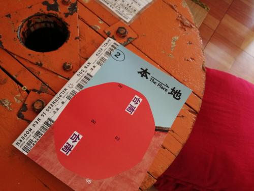 a sign on the side of a wooden table with a red pillow at 山露露品茶旅宿-一層一房 可包棟 in Tainan
