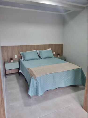 a bedroom with a large bed with blue pillows at LOFT DONA MARIA in Bento Gonçalves