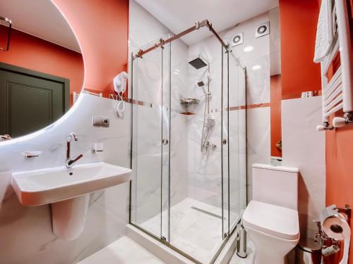 a bathroom with a shower and a sink at Trinity Hotel in Tbilisi City