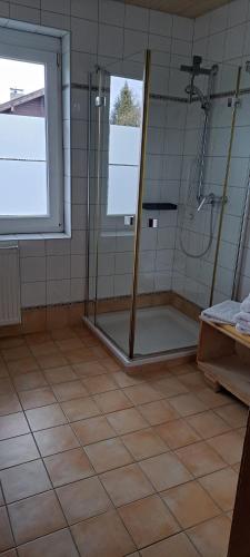 a bathroom with a shower and a tiled floor at Haus Pierzinger in Wörgl