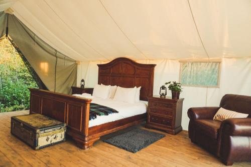 ein Schlafzimmer mit einem Bett und einem Sofa in einem Zelt in der Unterkunft Fronterra Farm- Luxury Camp Experiences in Hillier