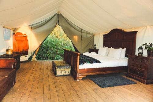 a bedroom with a tent with a bed and a couch at Fronterra Farm- Luxury Camp Experiences in Hillier