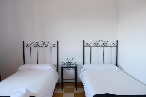 two beds sitting next to each other in a room at Casa de la Corredera in Arcos de la Frontera
