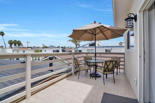 Un patio con una mesa y sillas y una sombrilla. en 114 Forty Second Street B, en Newport Beach