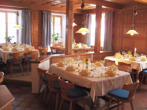 a dining room with many tables and chairs and tablesearcher at Gasthof zur Post Oberwirt in Chieming