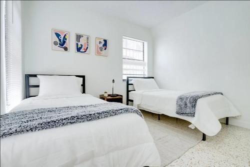 een witte slaapkamer met 2 bedden en een raam bij Havana Ooh La La - Little Havana Calle 8 by Pattio in Miami