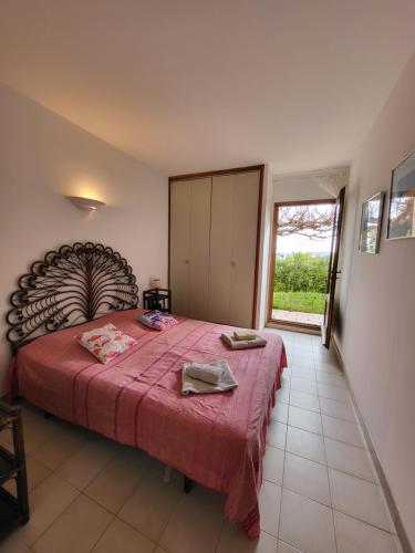una camera da letto con un letto grande con una coperta rossa di Maison Les couchants Porticcio a Porticcio