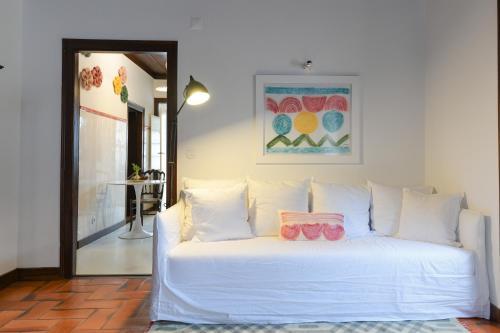 a white bed with pillows on it in a room at Casa do Pátio, casaspensadas in Juncal
