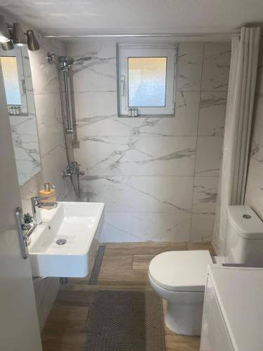 biała łazienka z umywalką i toaletą w obiekcie Thiseio Big Apartment w Atenach