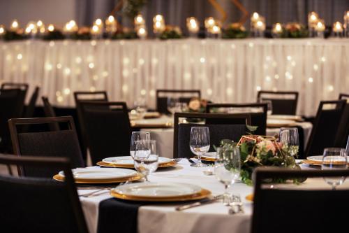 uma sala de jantar com mesas e cadeiras com copos de vinho em Courtyard Mankato Hotel & Event Center em Mankato