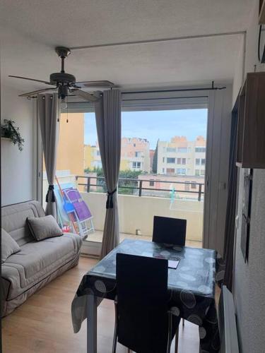 un salon avec un canapé et une table avec un ordinateur portable dans l'établissement Appart 5 pers port de Gruissan, à Gruissan